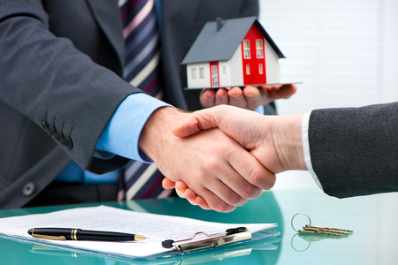 52325998 – estate agent shaking hands with customer after contract signature