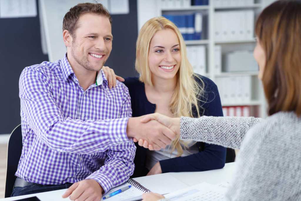 Smiling pleased couple shaking hands