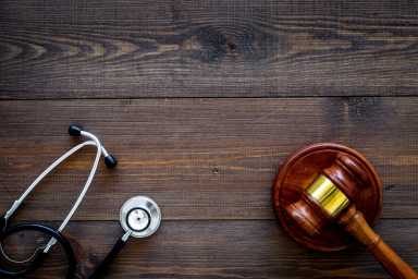Medical law, health law concept. Gavel and stethoscope on dark wooden backgound top view copy space