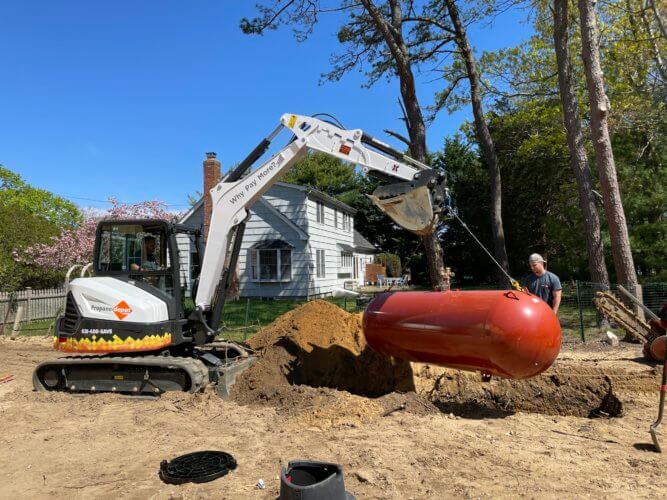 A PROPANE DEPOT TANK BEING BURIED BY THE TEAM’S EXPERT EXCAVATORS