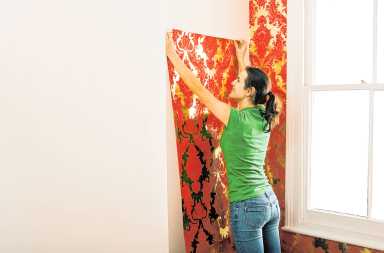 Woman hanging wallpaper