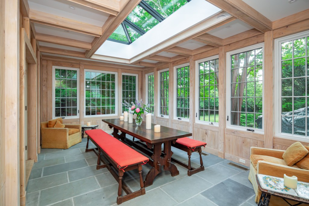 A copper-clad, glass conservatory with bluestone flooring makes for a notable addition to the home.